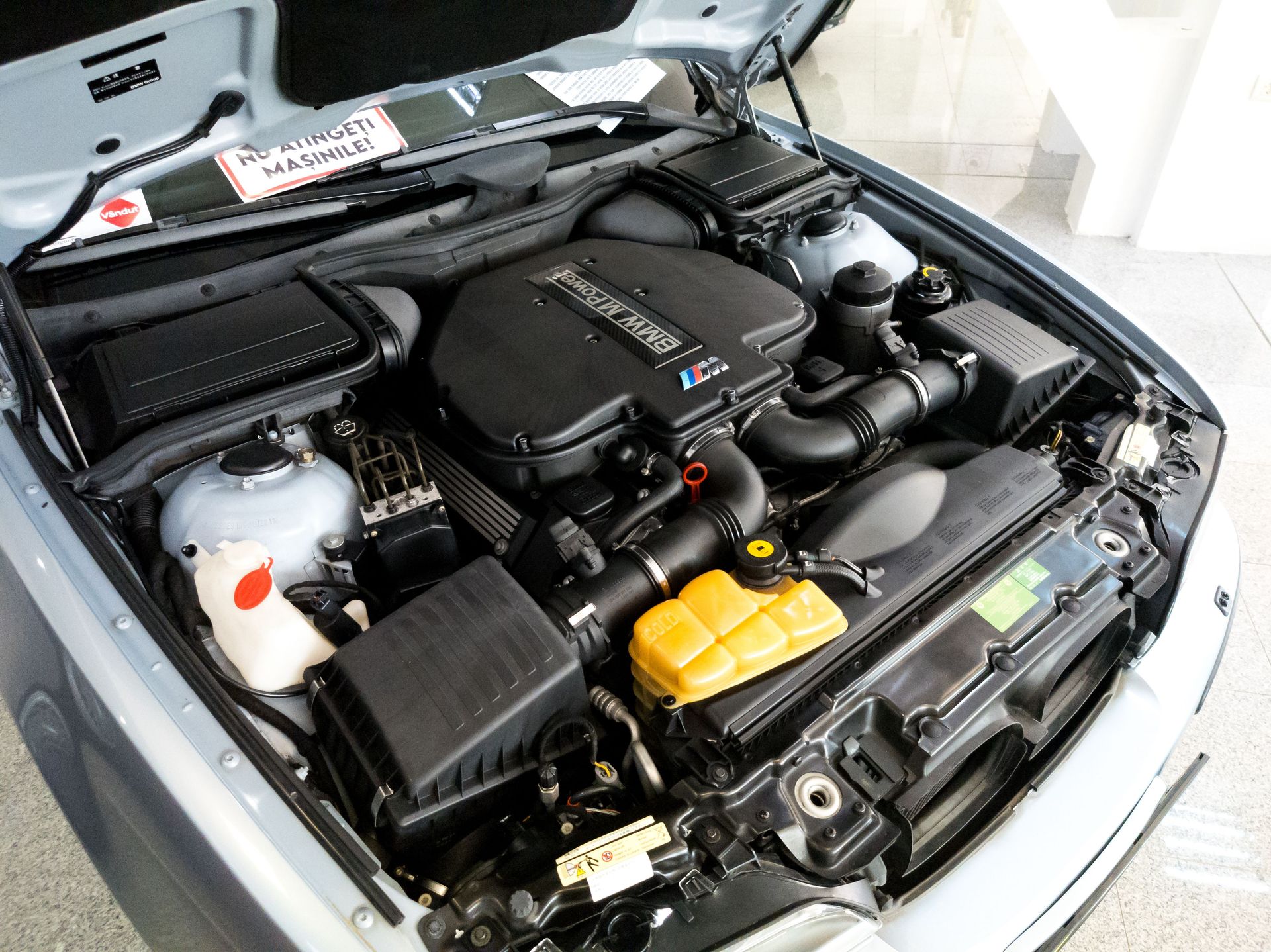 Close-up view of a car engine with open hood displaying intricate details and components.